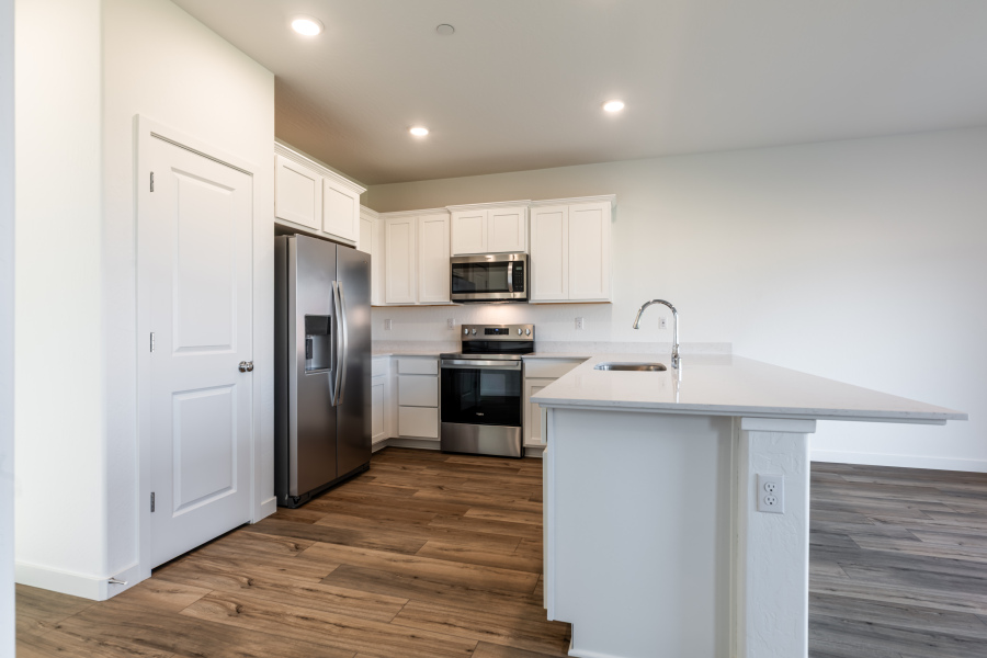 A kitchen with white cabinets.