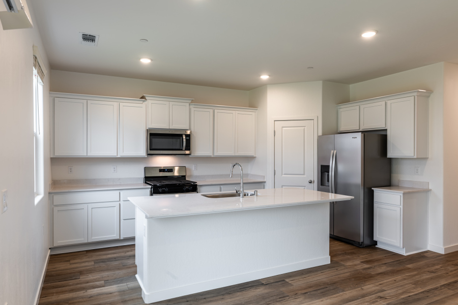 A kitchen with white cabinets.