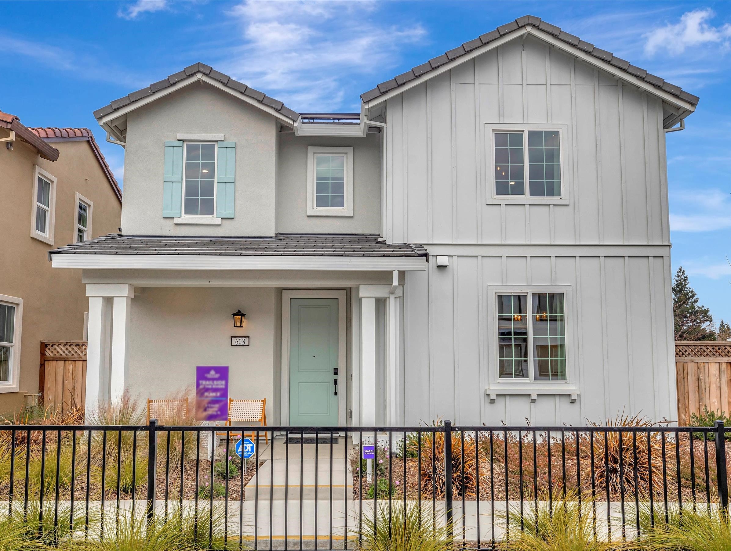 A white house with a black fence.