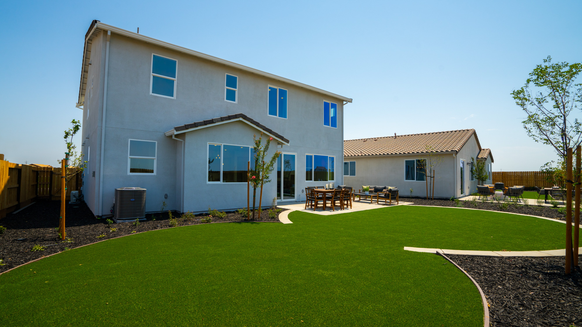 A house with a lawn and chairs.