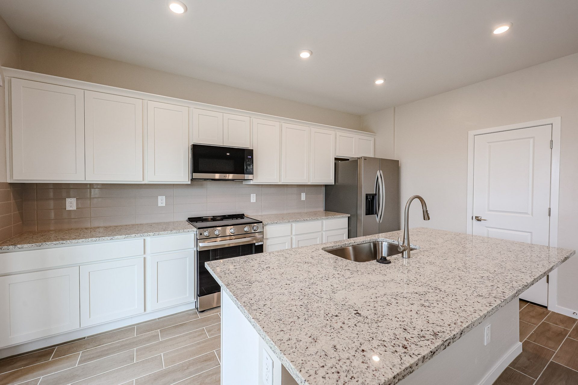 A kitchen with white cabinets.