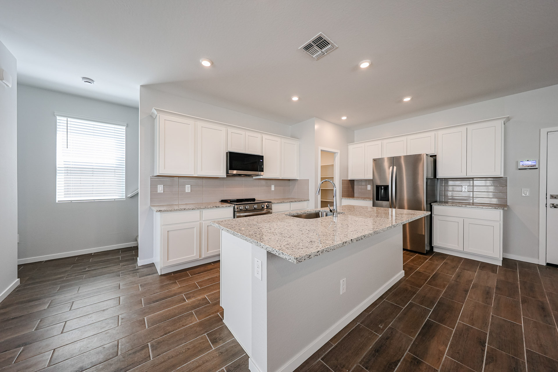A kitchen with white cabinets.