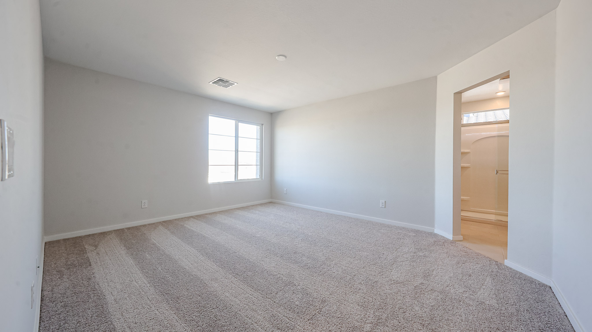 A room with a carpet and a door.