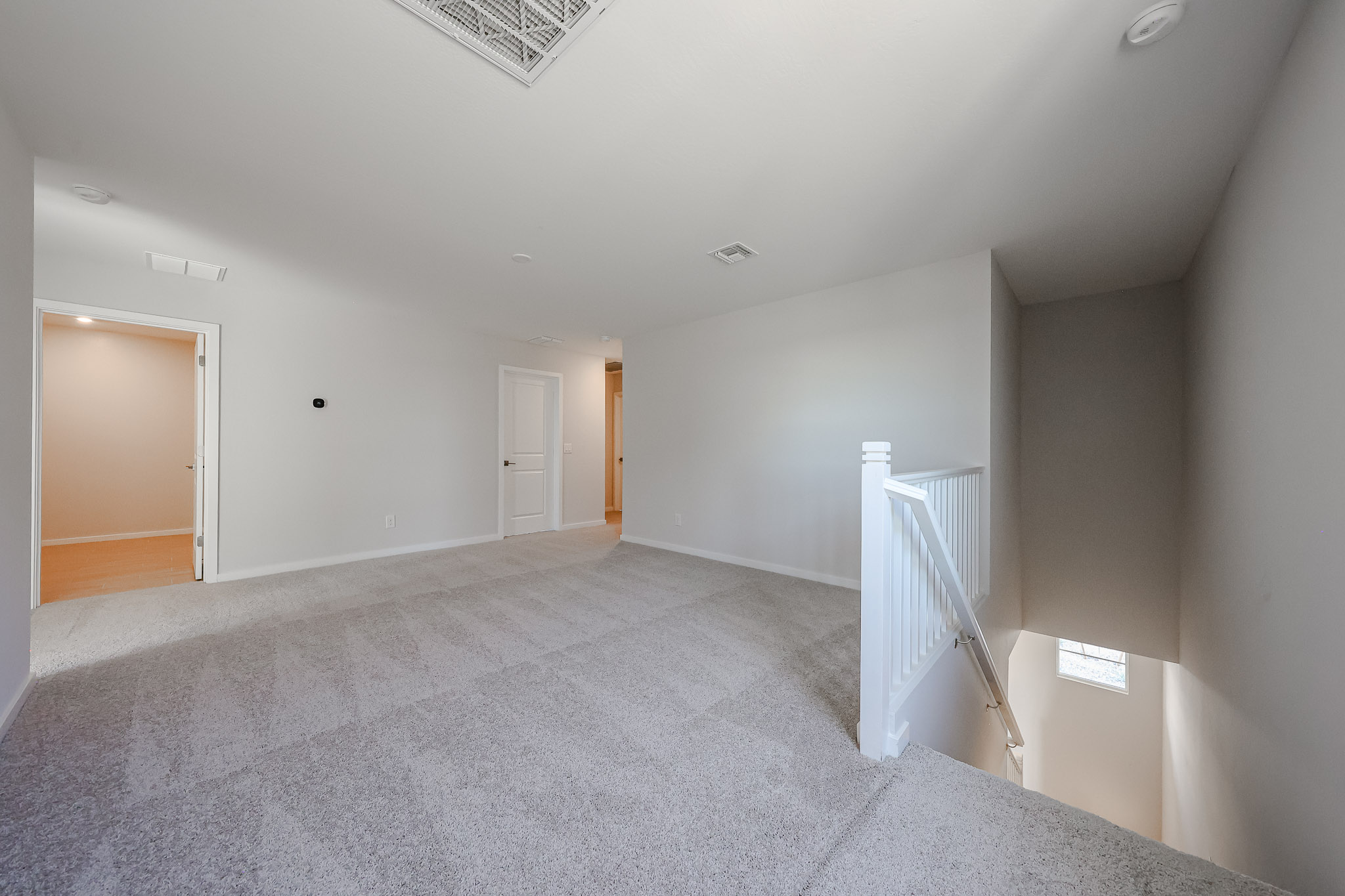 A long hallway with white doors.