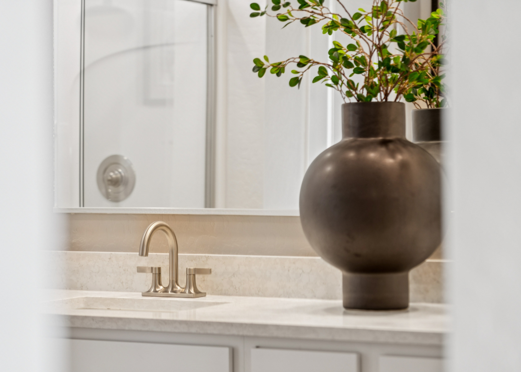 photo up close of bathroom brushed nickel hardware, marble counters, shower, and model home decor editorial lifestyle shot at the lakes at rancho el dorado model home in maricopa, AZ with close access to the 347.