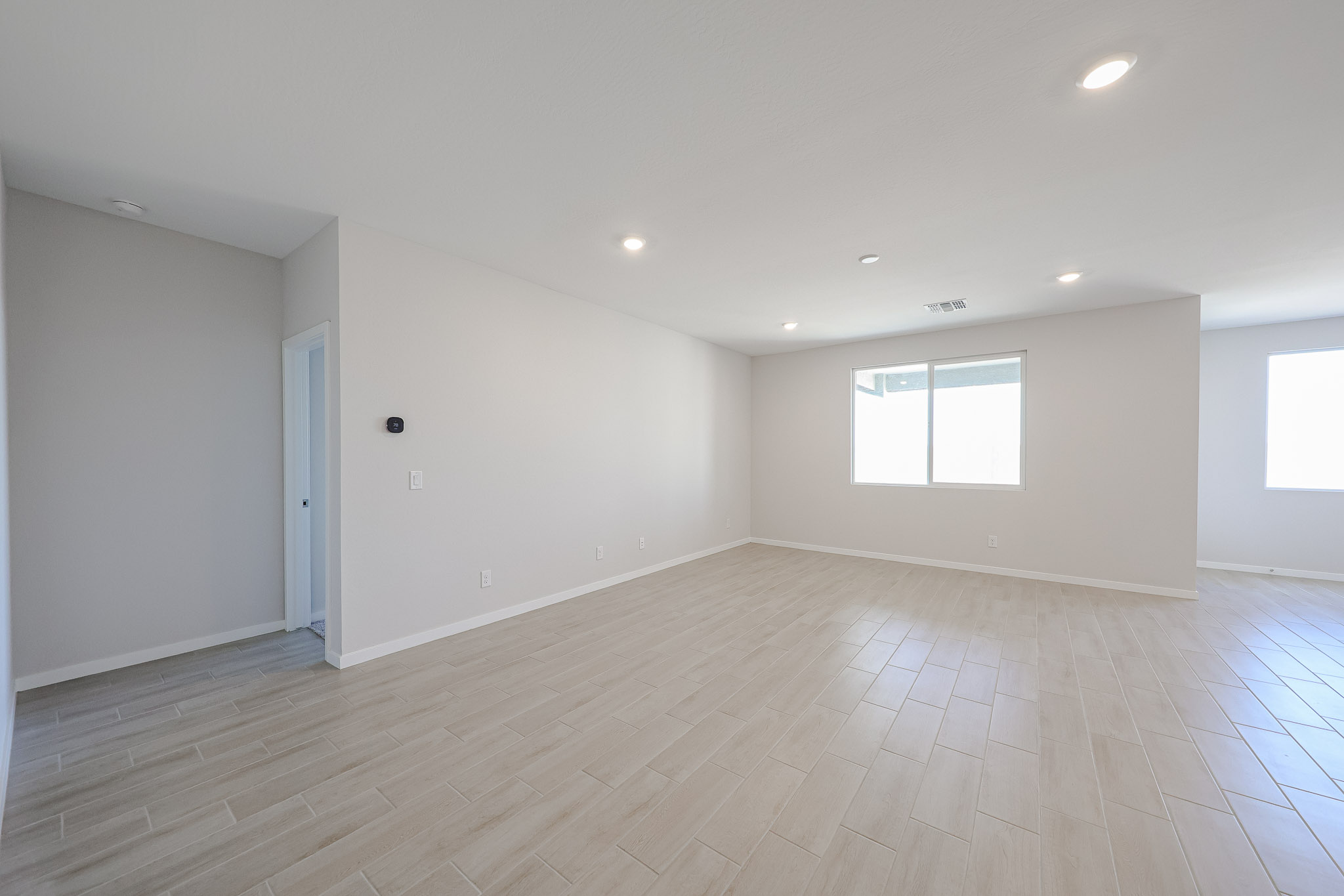 A room with a wood floor and windows.