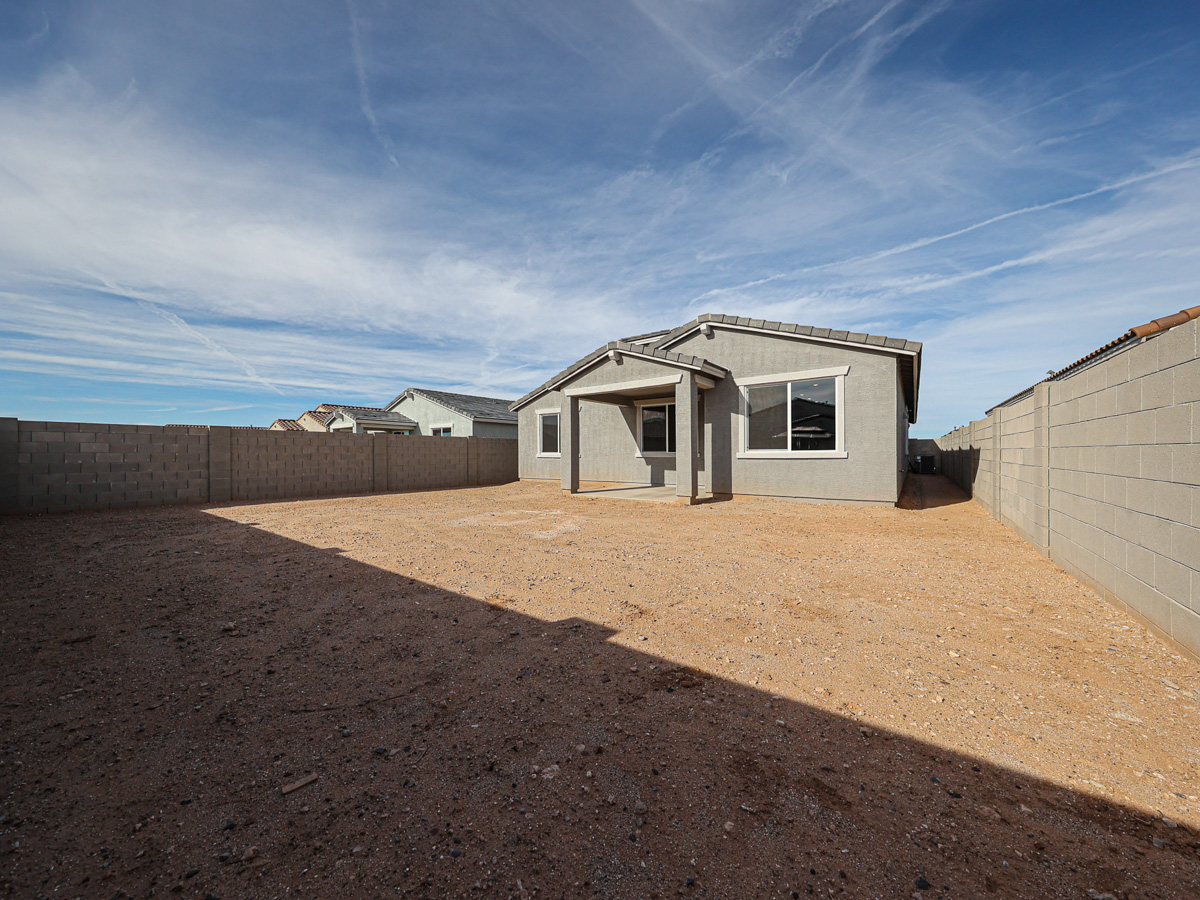 A dirt area with buildings in the background.