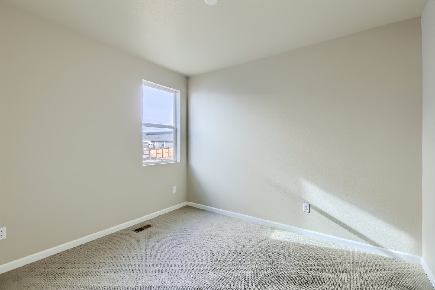 A room with a window and a carpet.