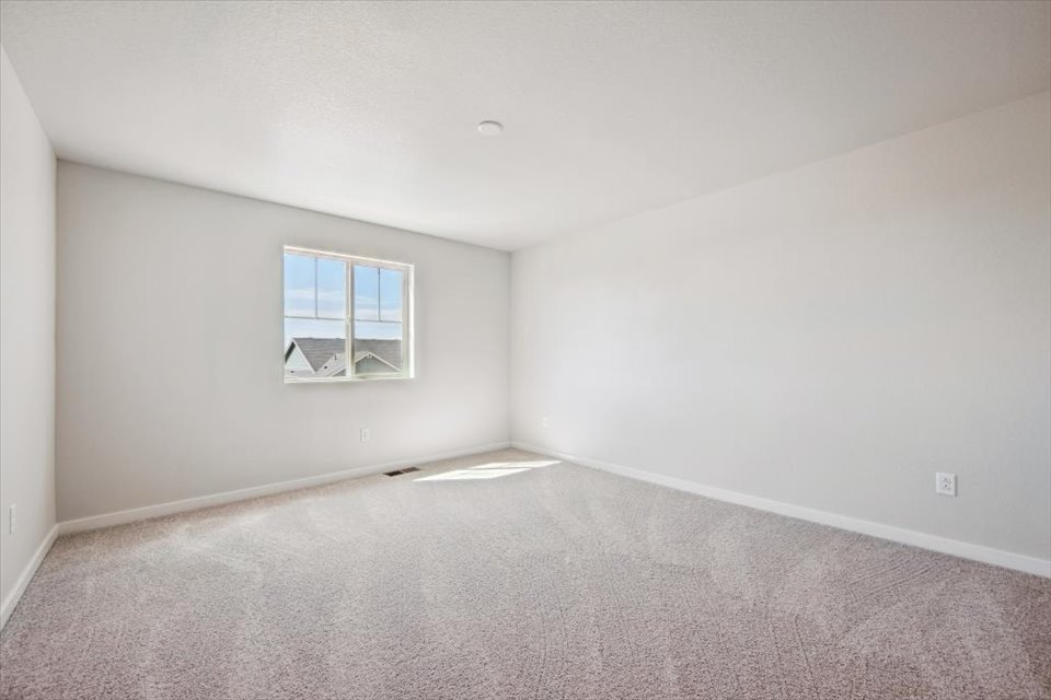 A room with a window and carpet.