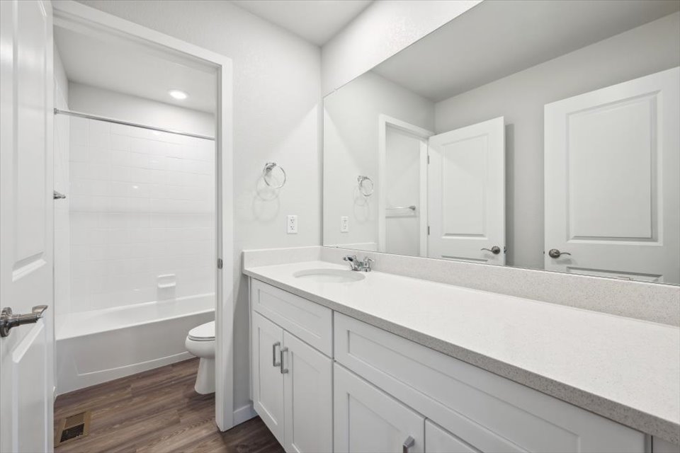 A bathroom with a tub sink and toilet.