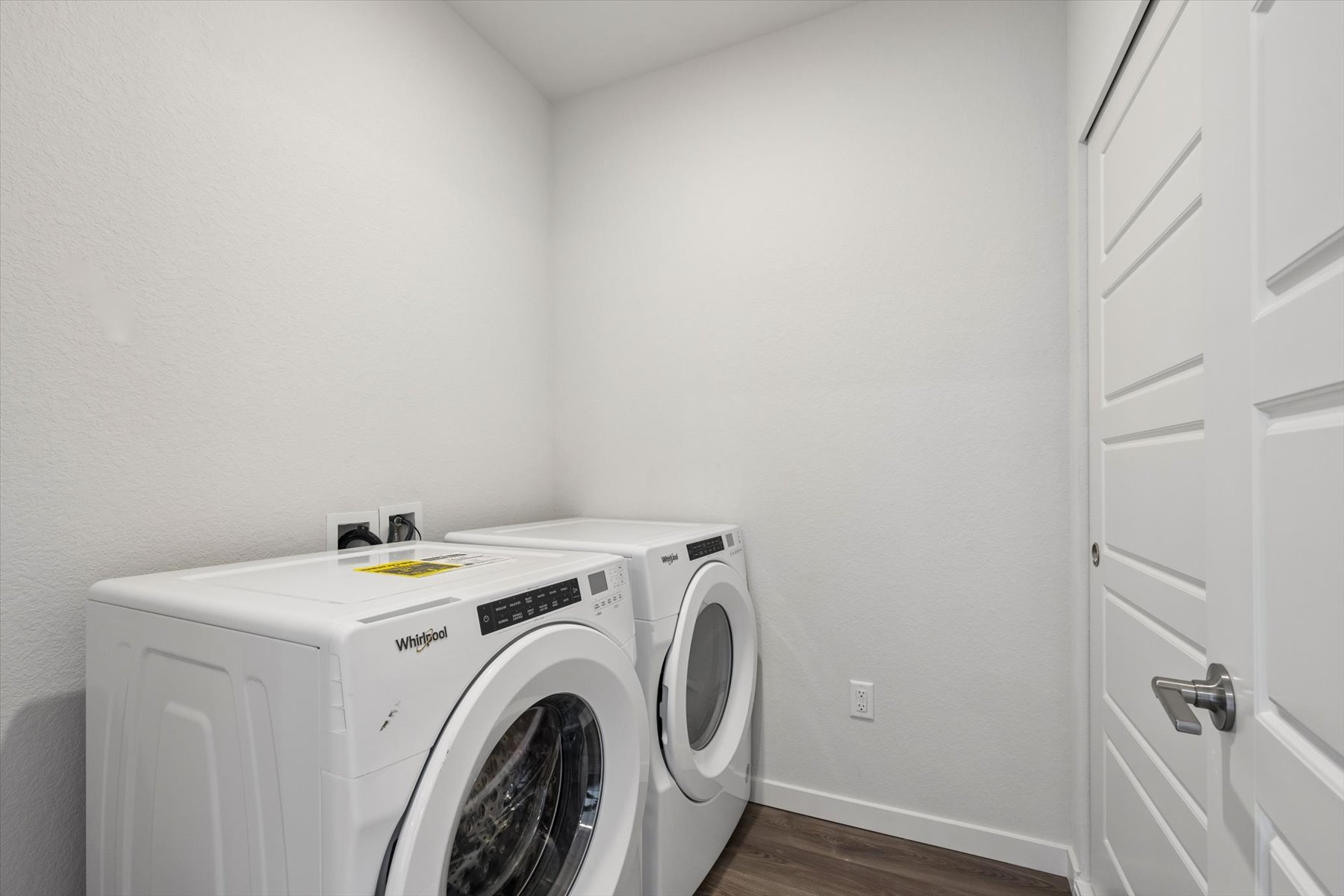 A white laundry machine in a room.