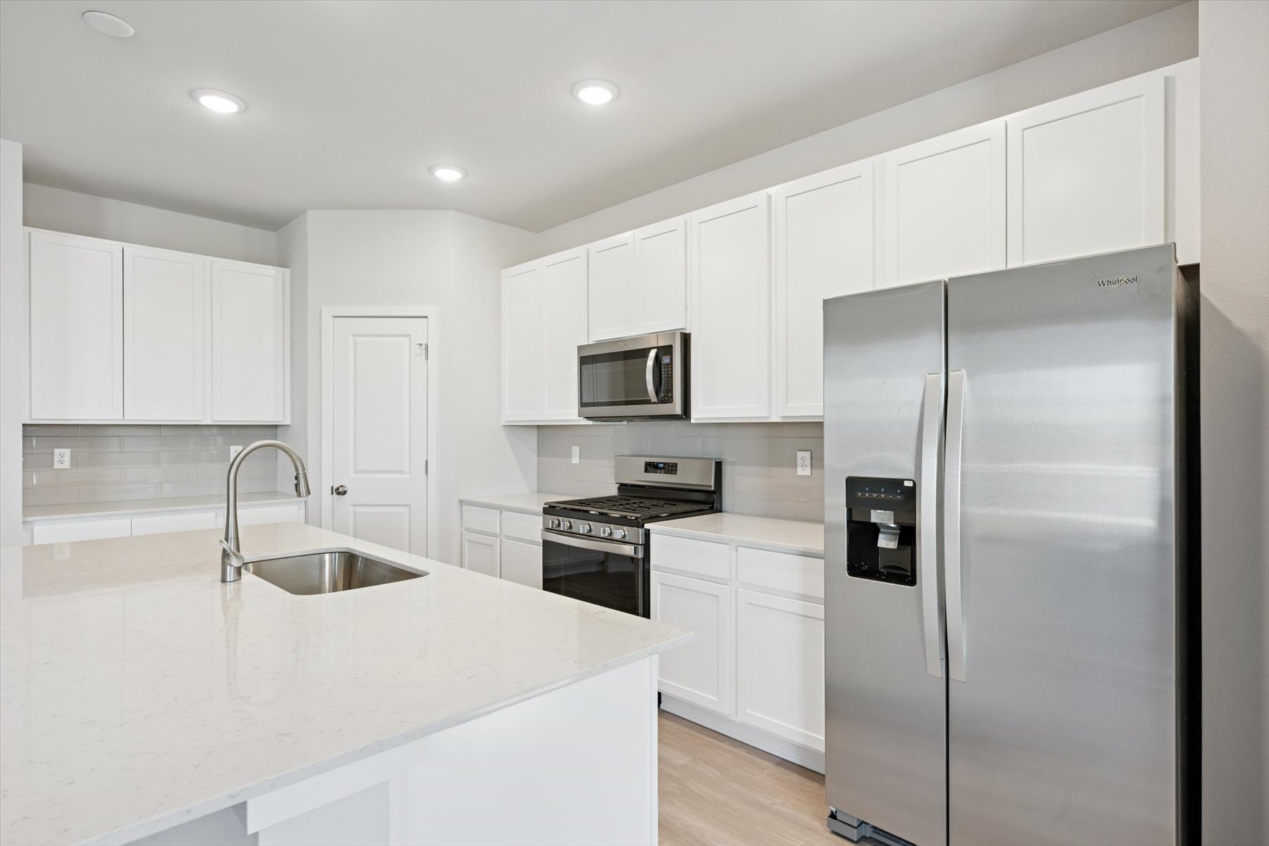 A kitchen with white cabinets.