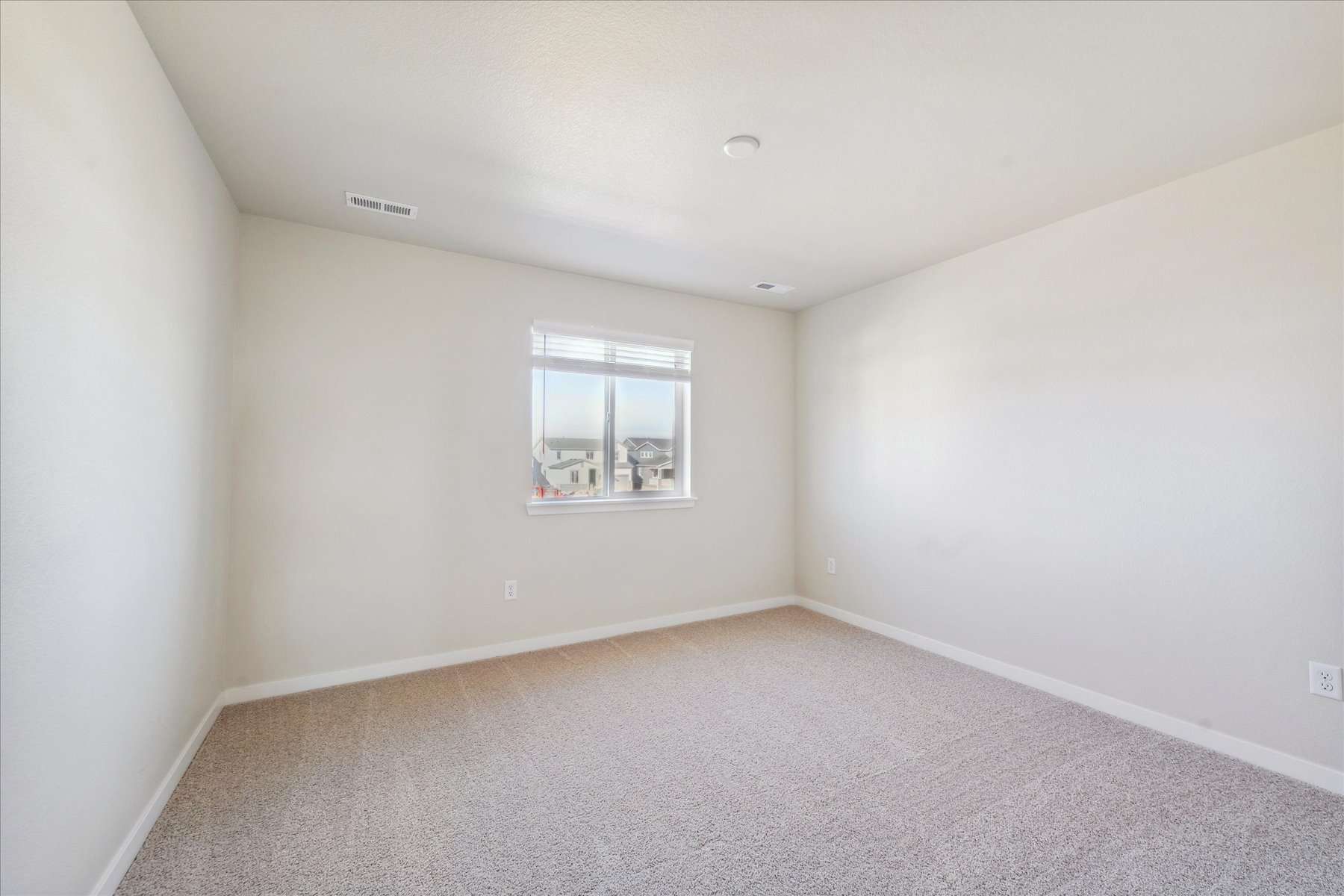 A room with a window and a carpet.