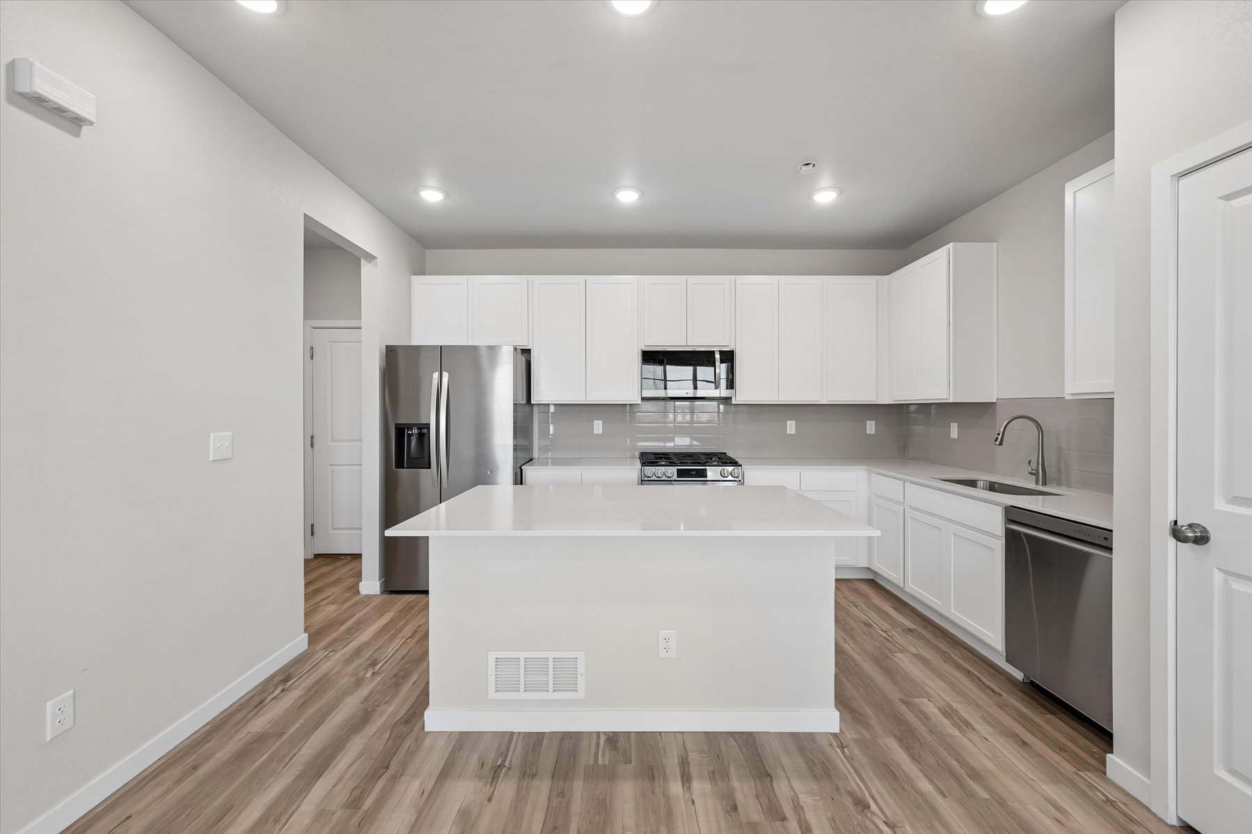 A kitchen with white cabinets.