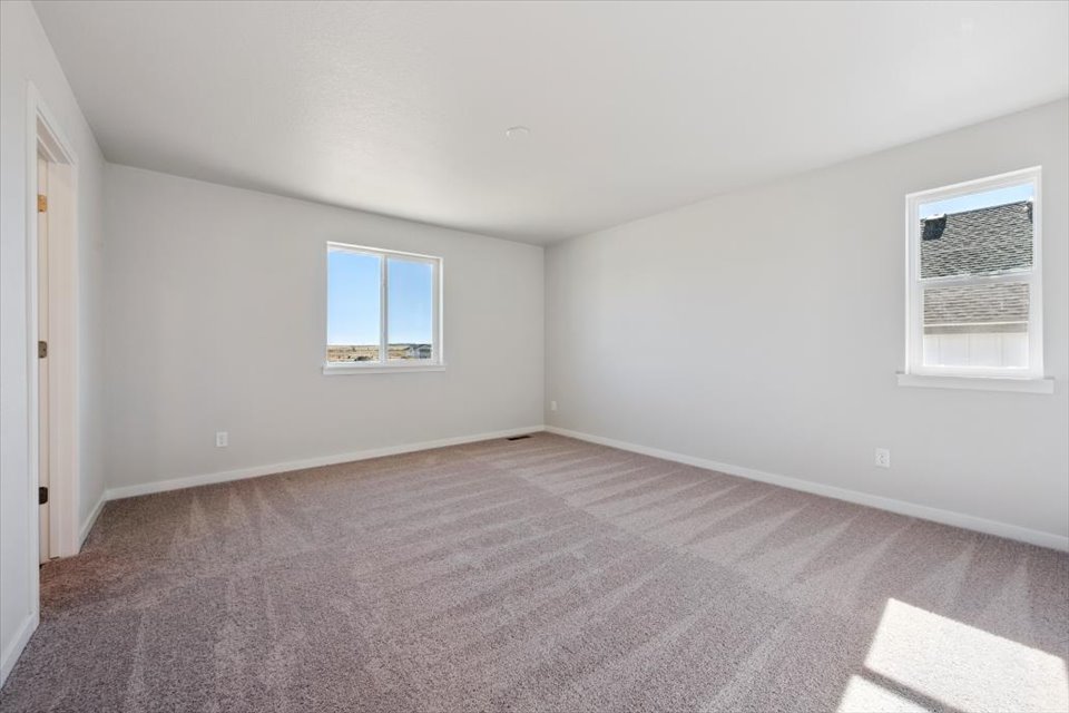 A room with a carpet and windows.