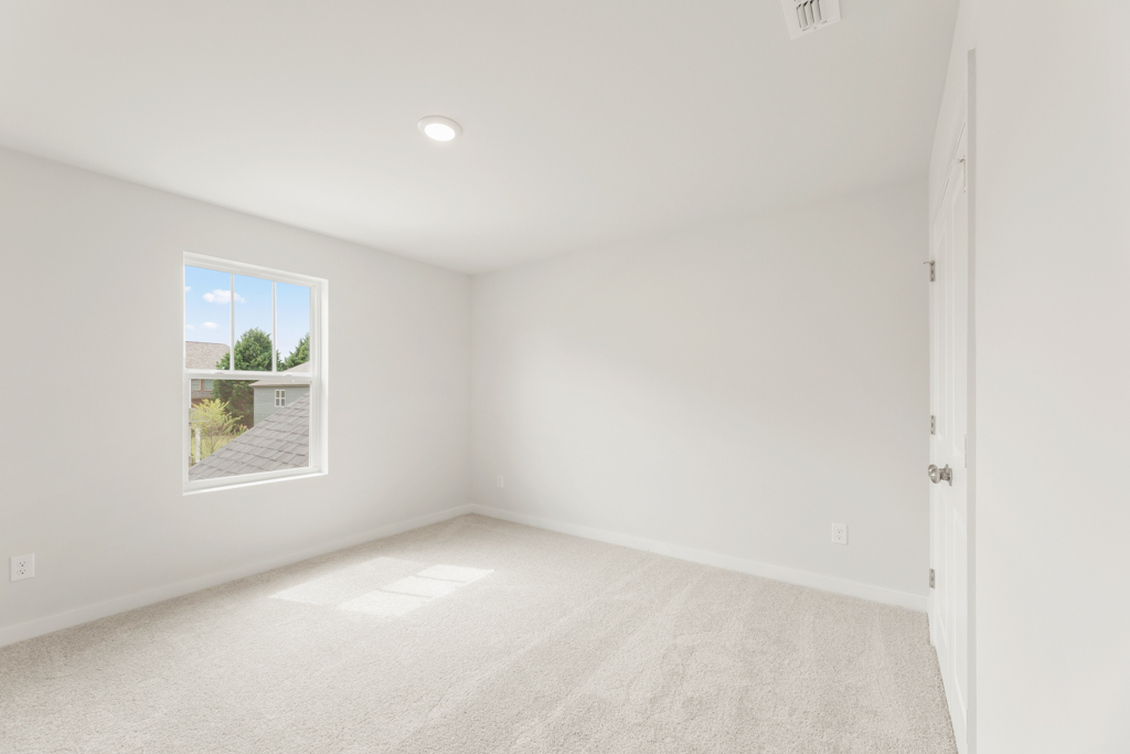 A room with a window and a carpet.