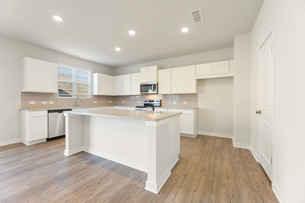 A kitchen with white cabinets.