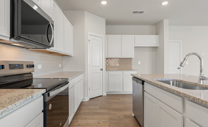 A kitchen with white cabinets.