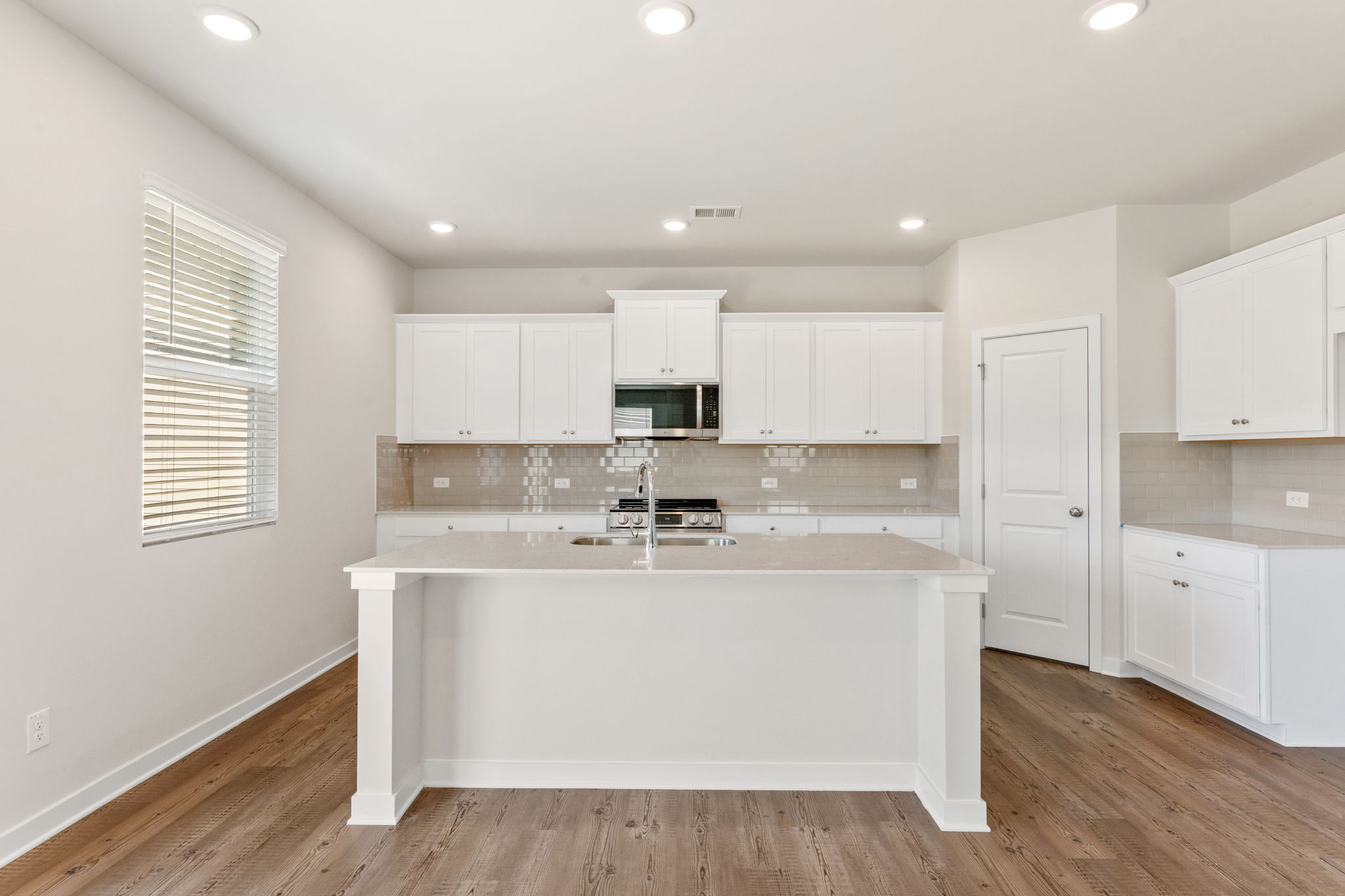 A kitchen with white cabinets.
