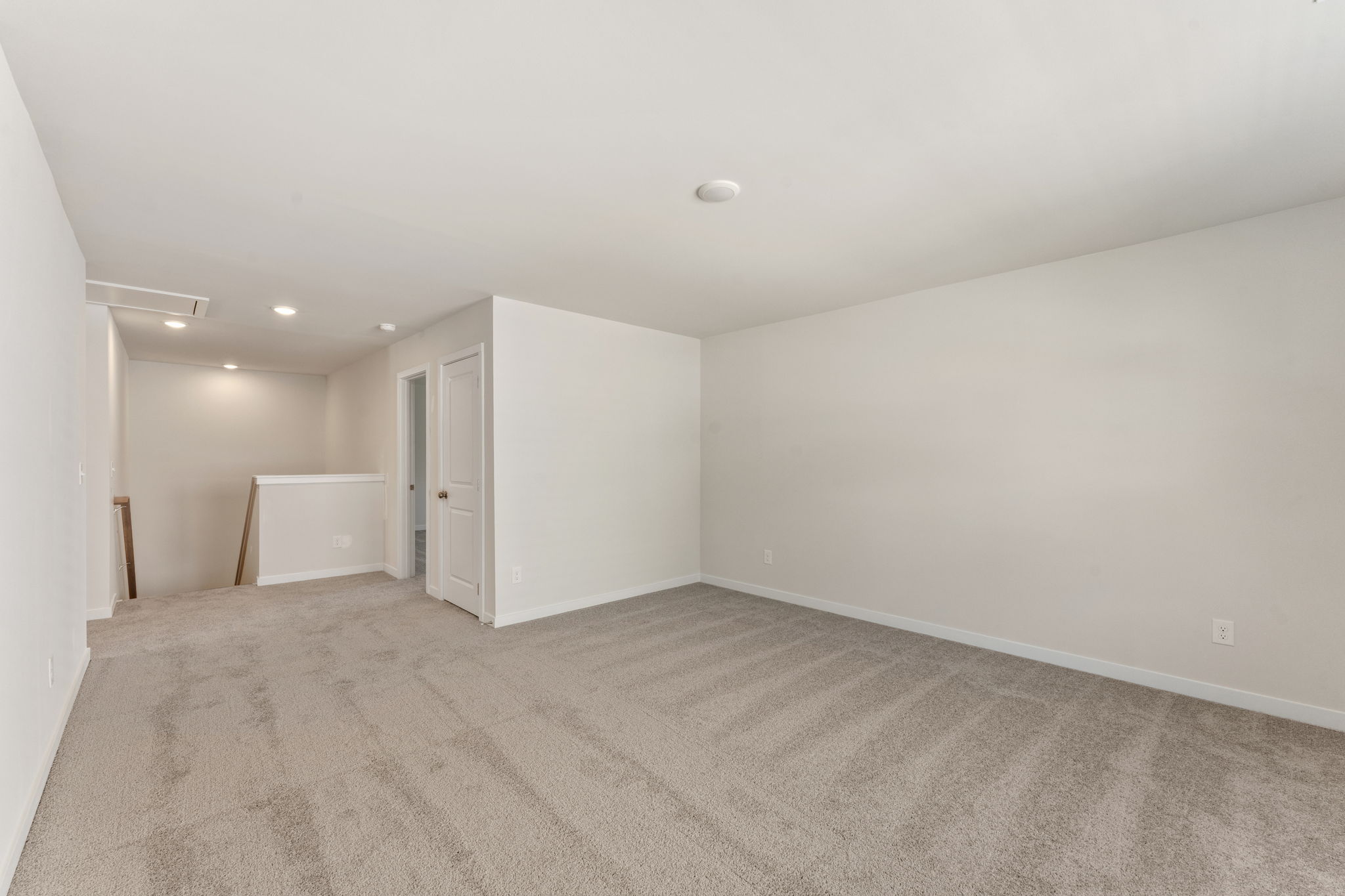 A room with a carpet and a white wall.