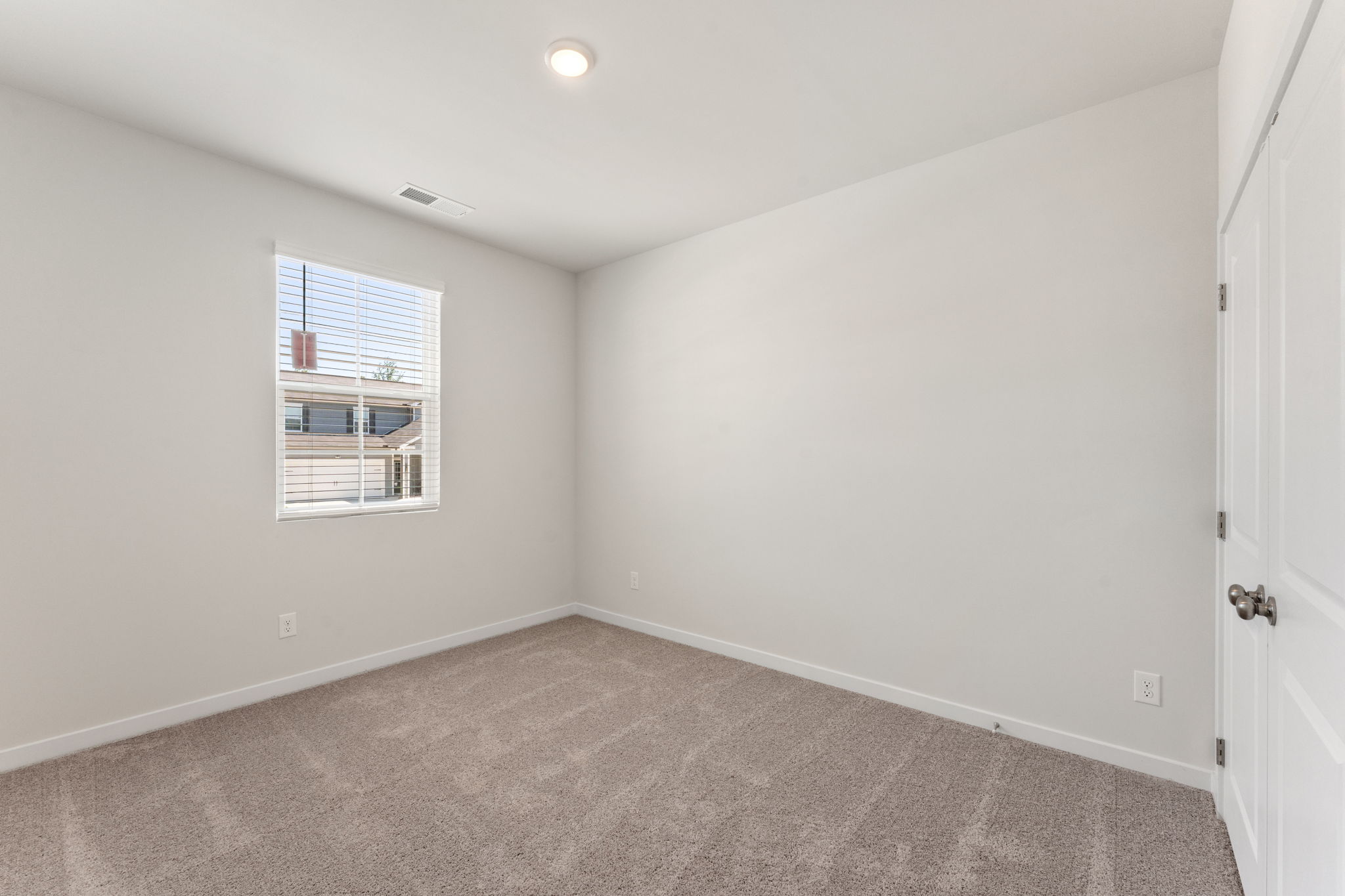 A room with a carpet and a window.