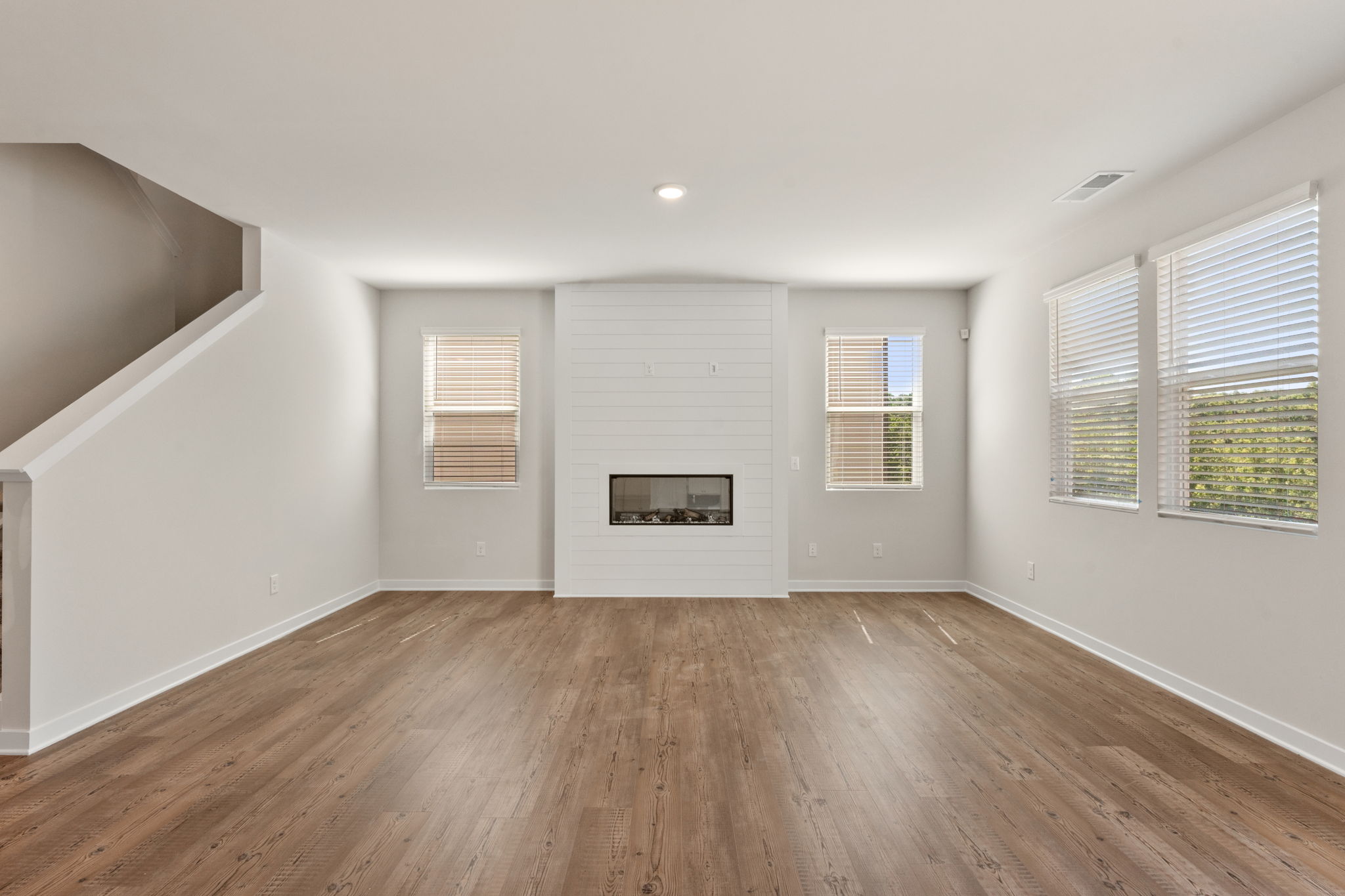 A room with a wood floor and windows.