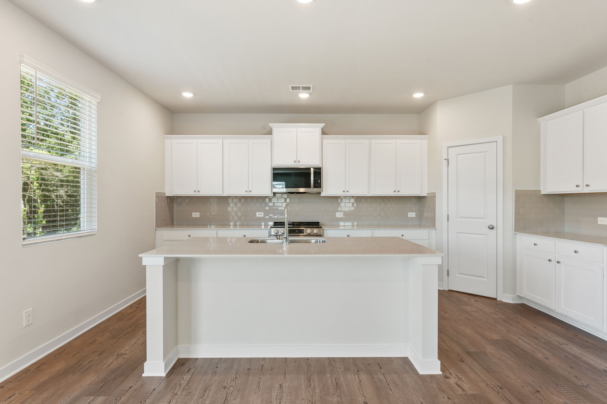 A kitchen with white cabinets.