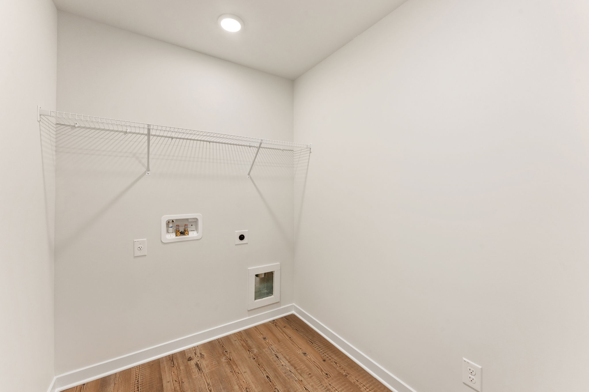 A white room with a wood floor.