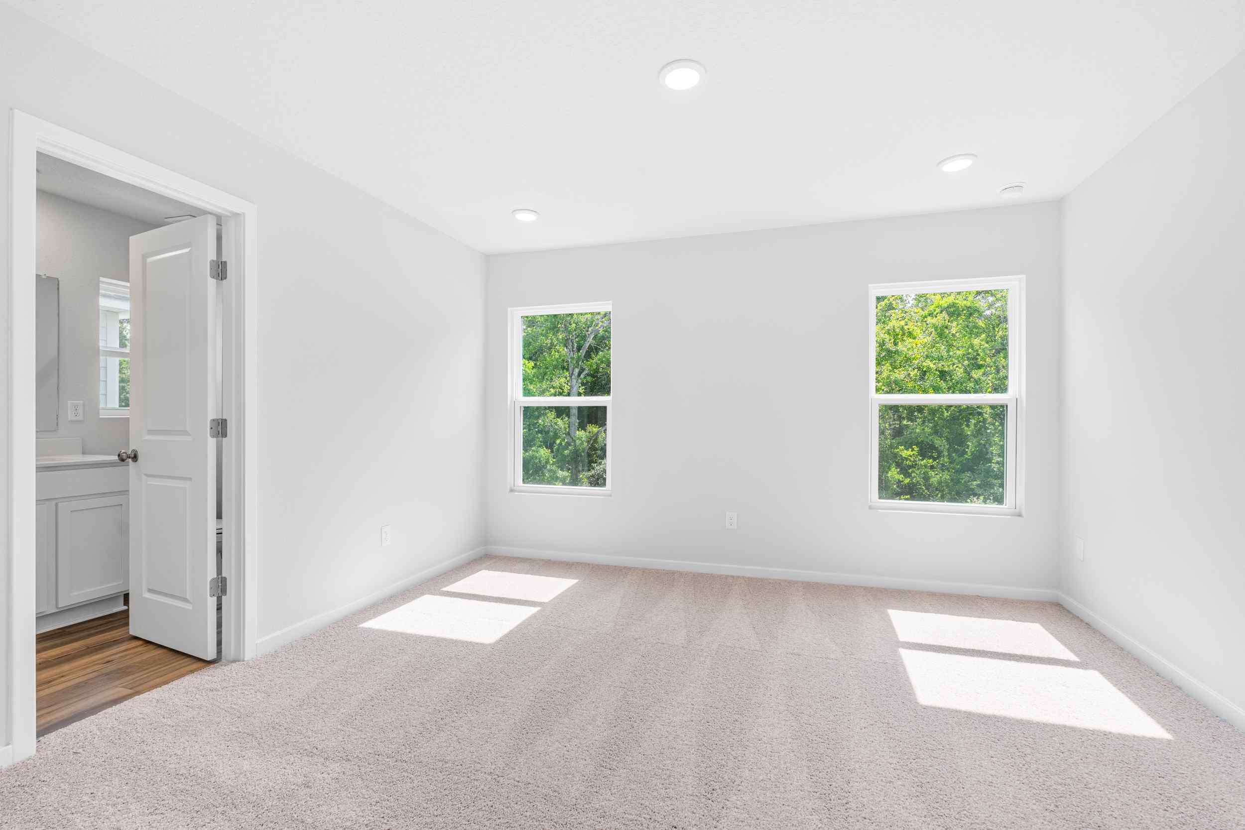 Davor Paired Home Primary Bedroom with Two Windows at The Landings at Pecan Park in Jacksonville