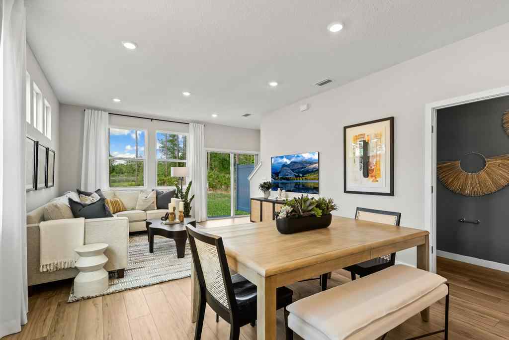 A living room with a large table and chairs.