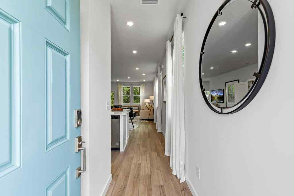 A hallway with a mirror and a desk.