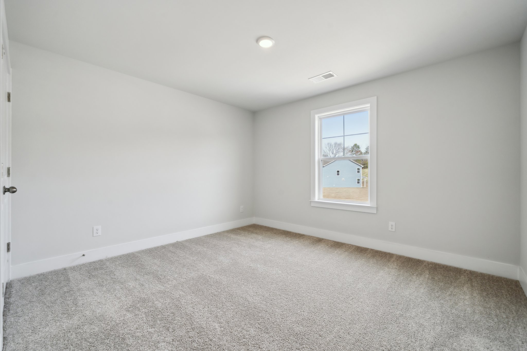 A room with a window and a carpet.