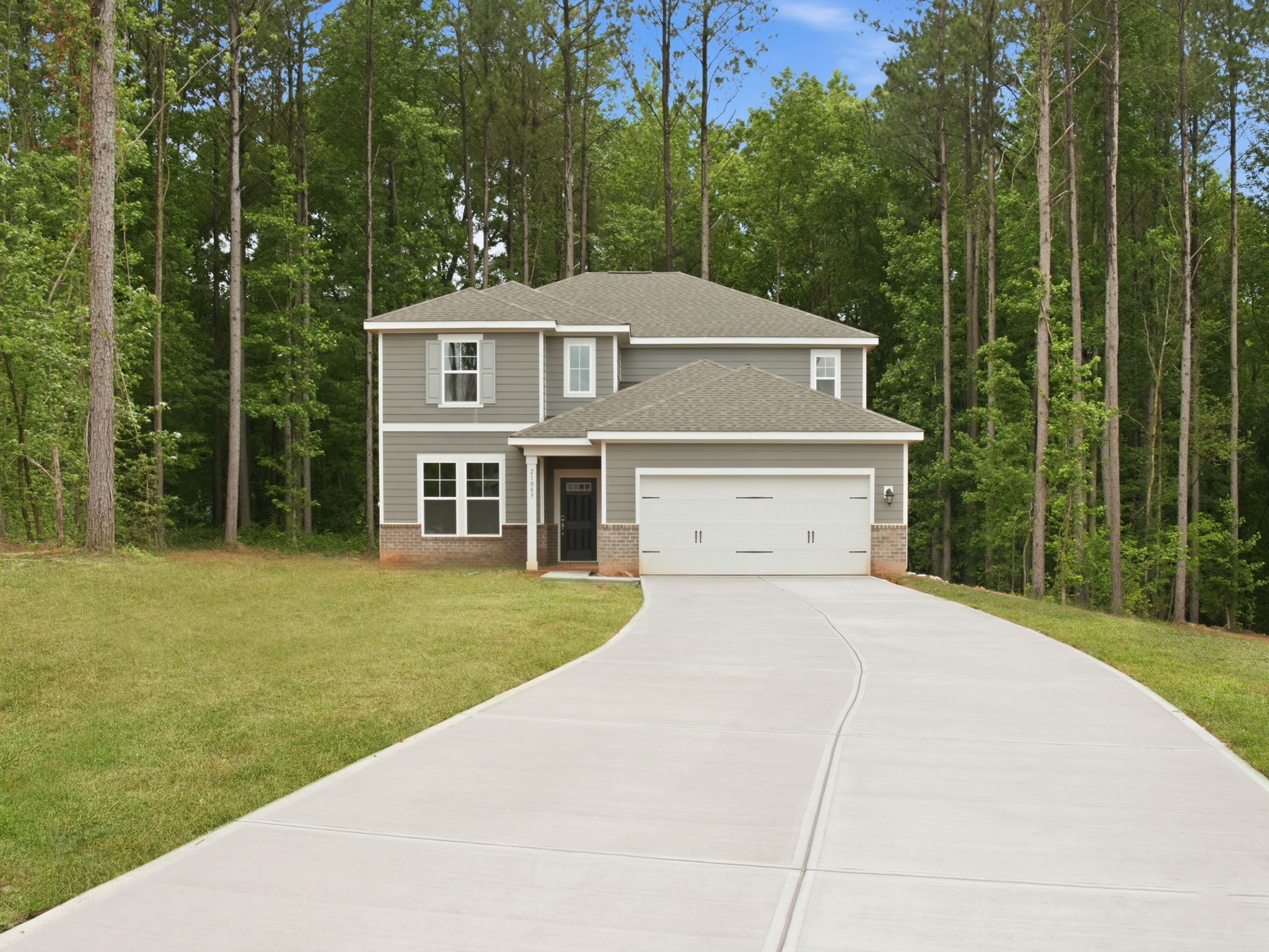 A house with a driveway and trees around it.