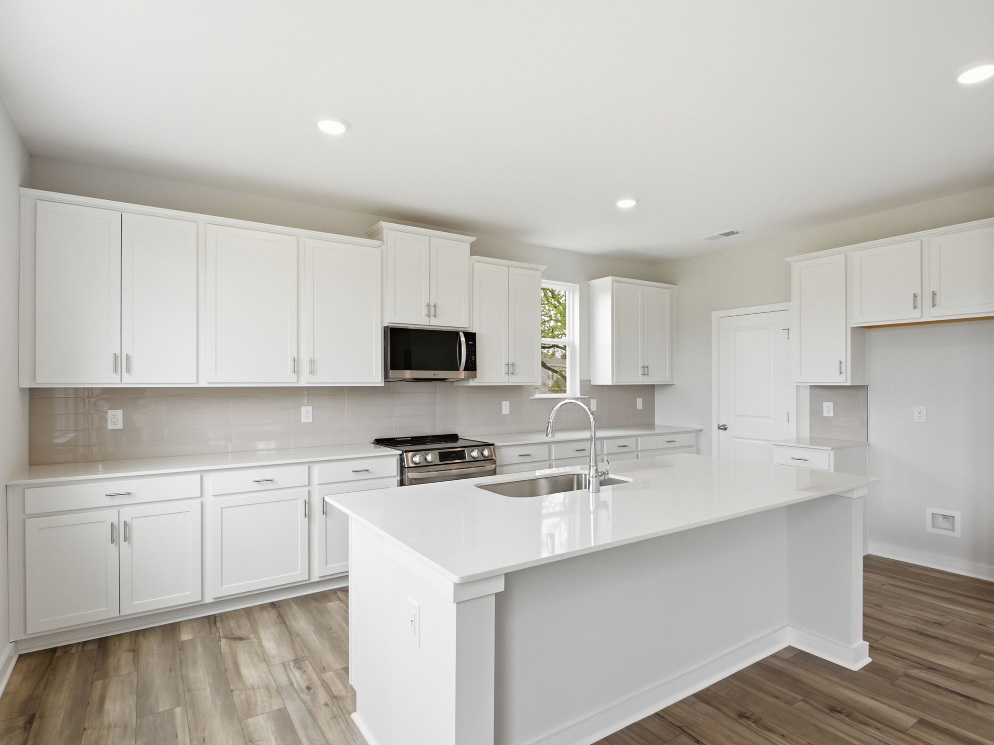 A kitchen with white cabinets.