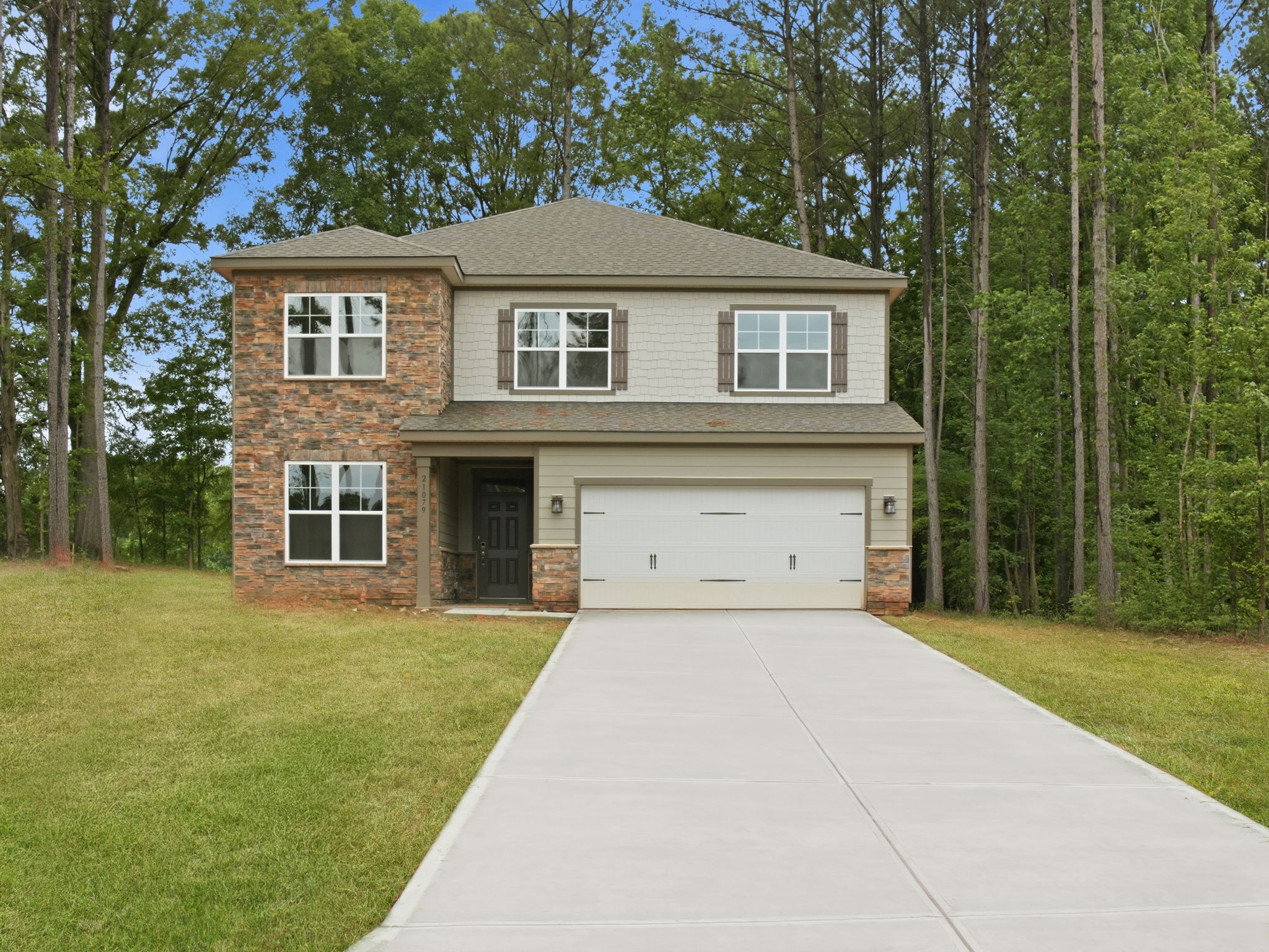 A house with a garage and trees around it.