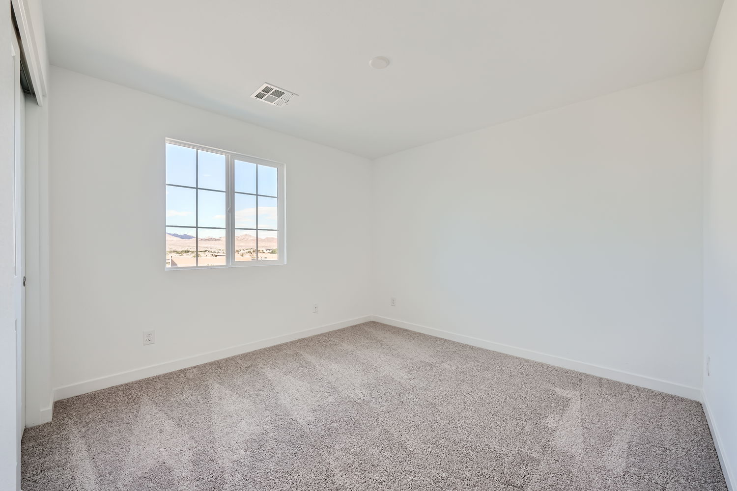 A room with a window and a carpet.
