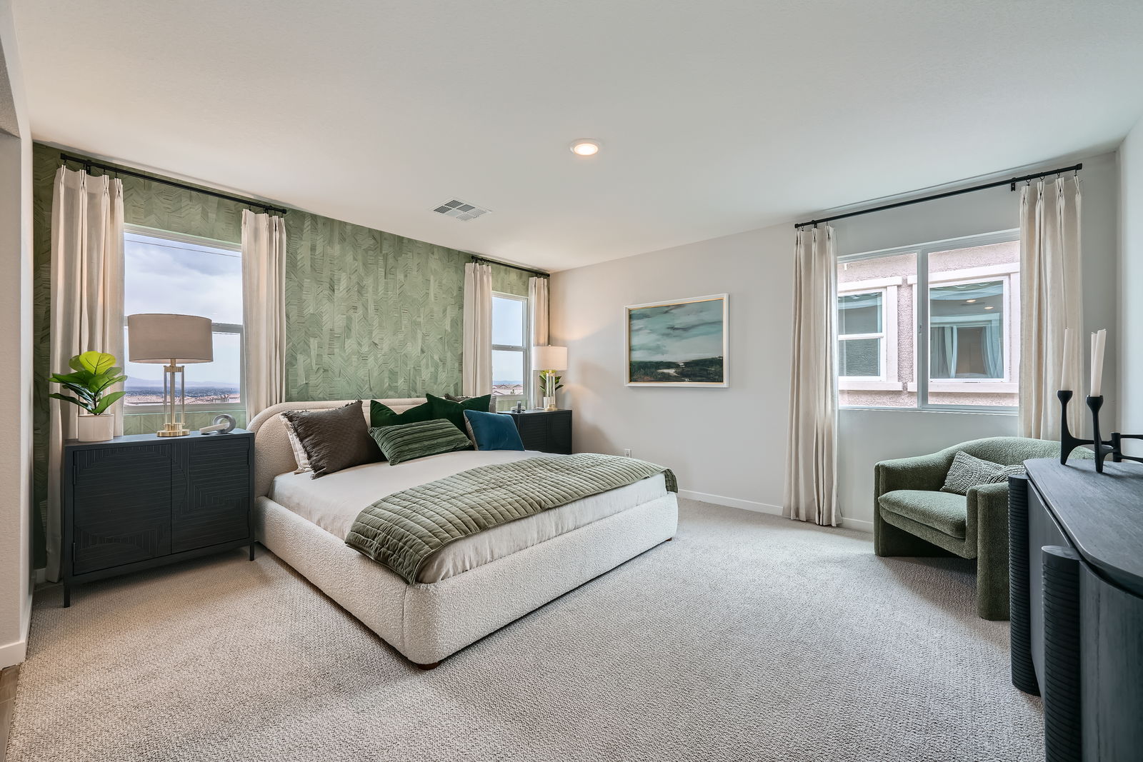 A large bedroom with a couch and a chair.