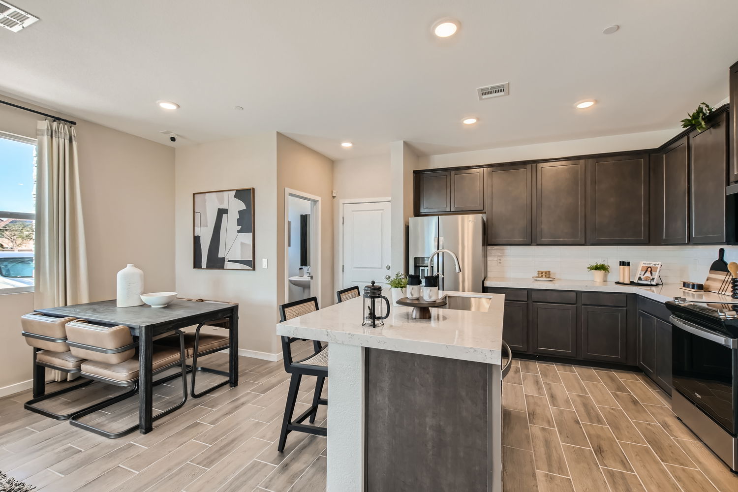 A kitchen with a table and chairs.