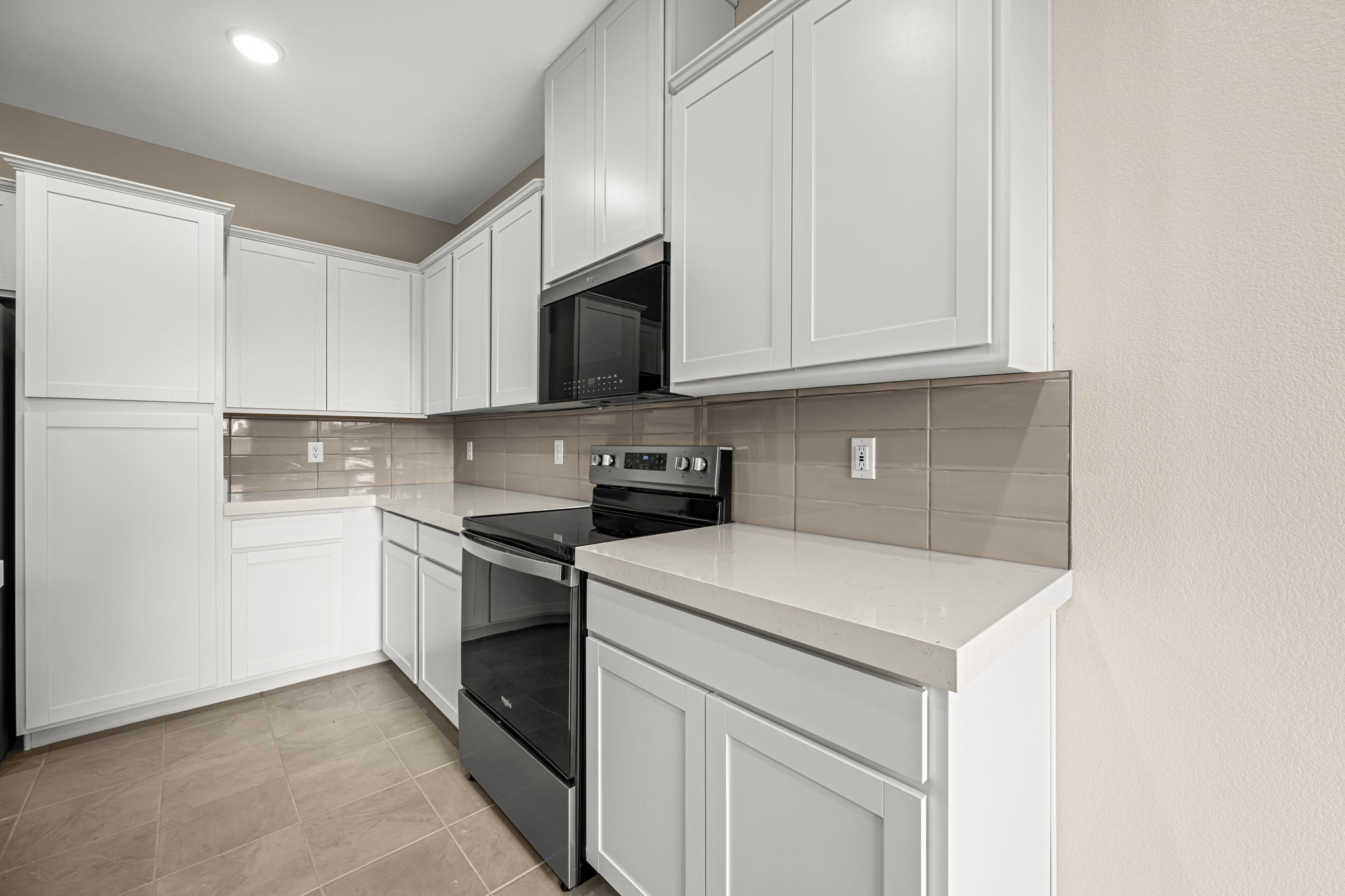 A kitchen with white cabinets.