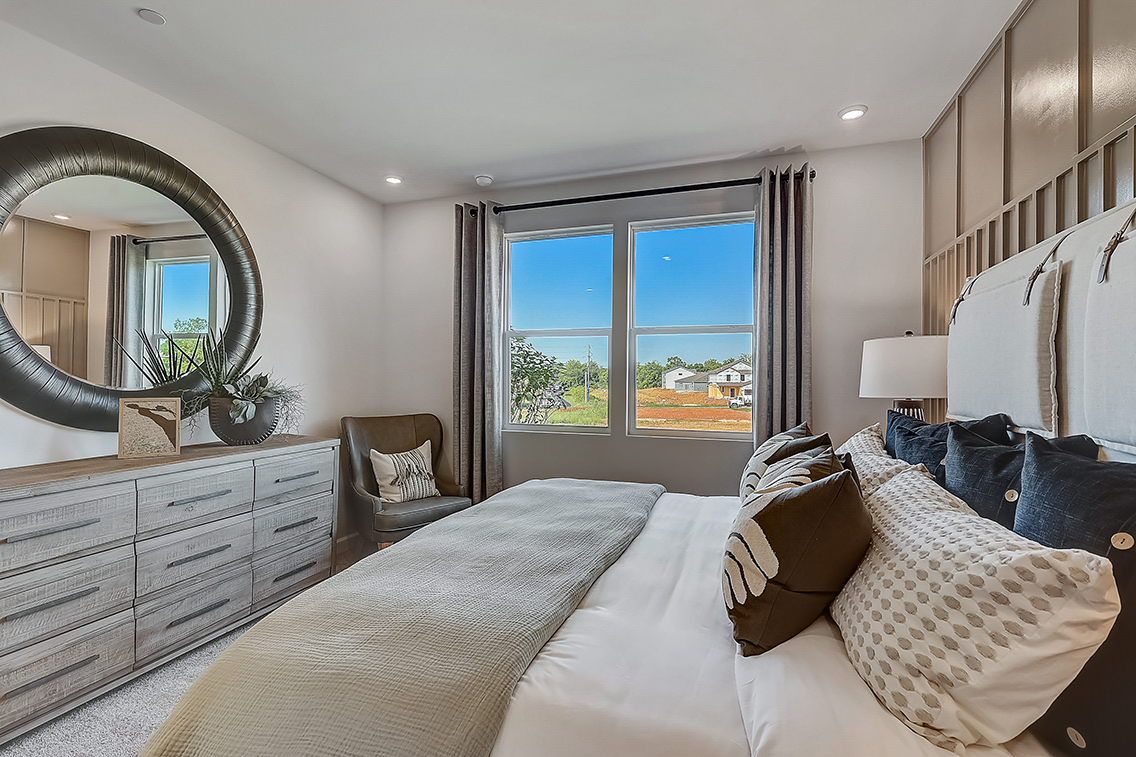 A bedroom with a large window.