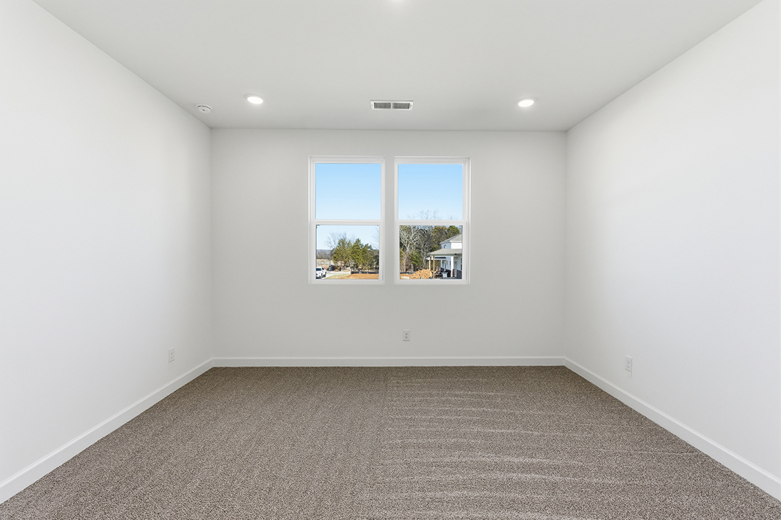 A room with a window and a carpet.
