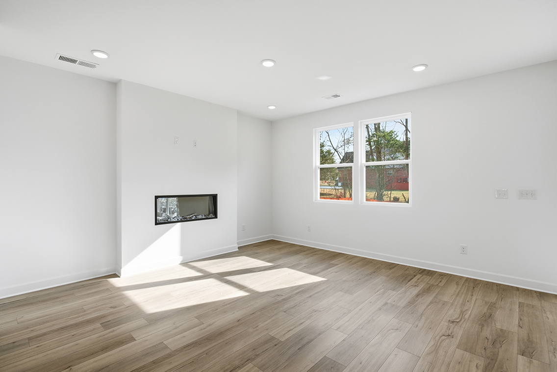 A room with a wood floor and a wood floor with a window.