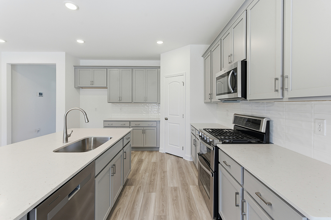 A kitchen with white cabinets.