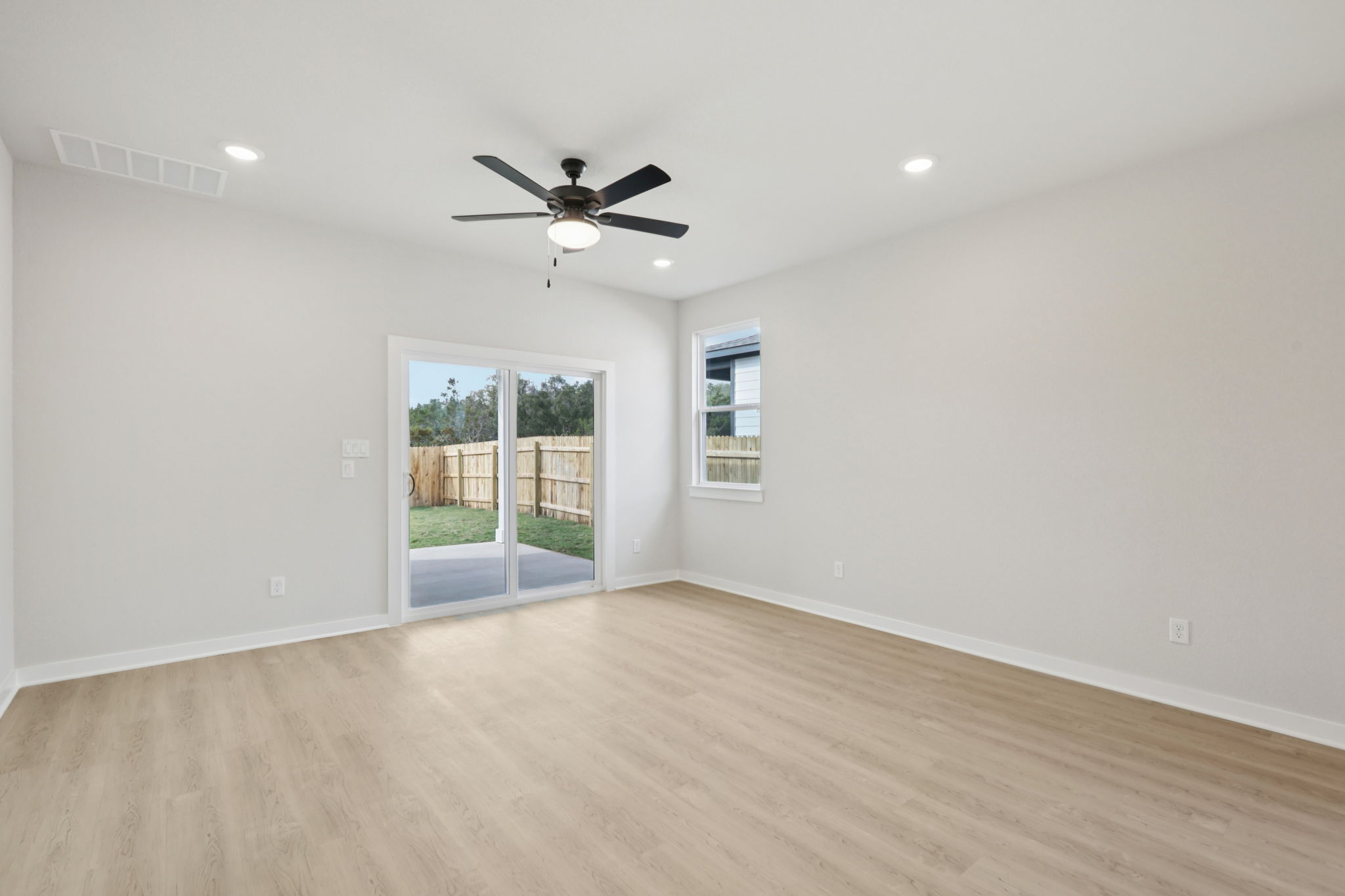 A room with a wood floor and a ceiling fan.