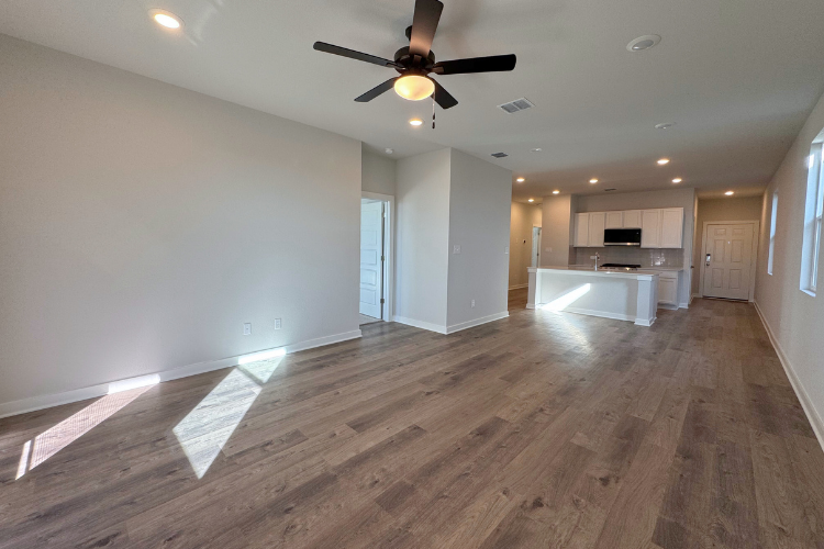 A room with a wood floor and a ceiling fan.