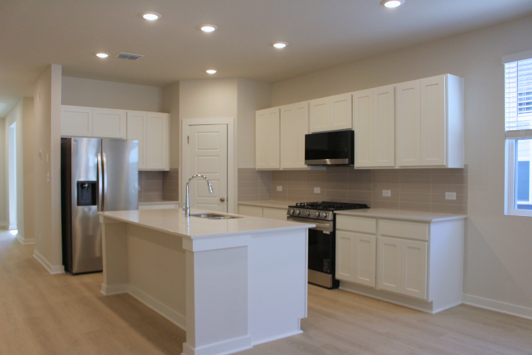 A kitchen with white cabinets.