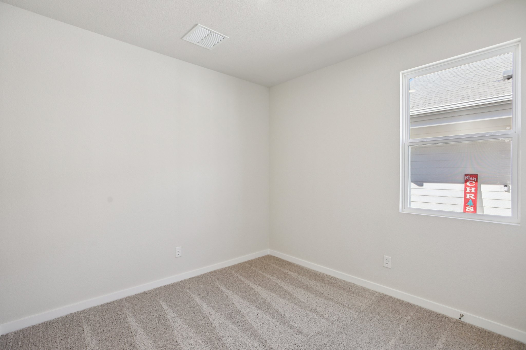 A room with a window and a rug.