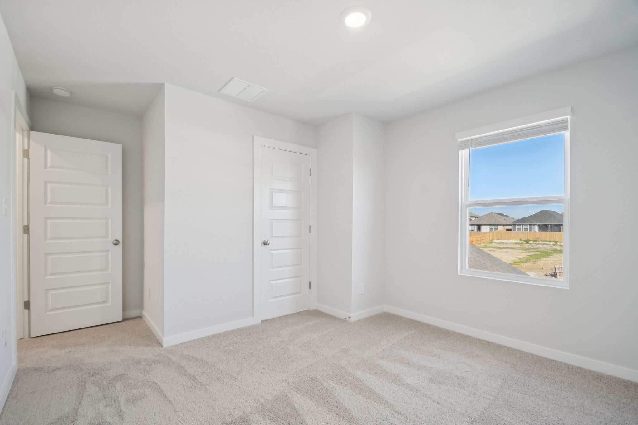 A room with white doors and a window.