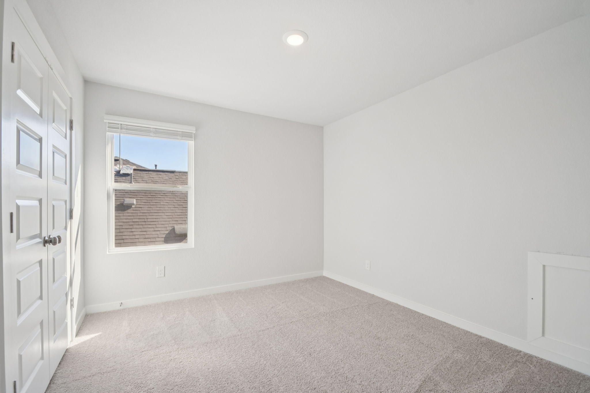 A room with white walls and a window.