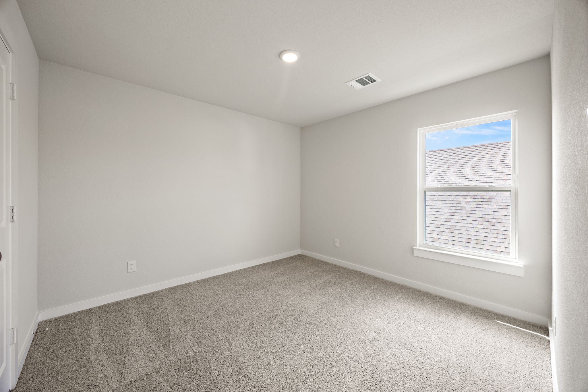 A room with a carpet and a window.